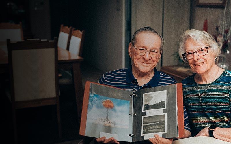 elderly couple with binder of pictures
